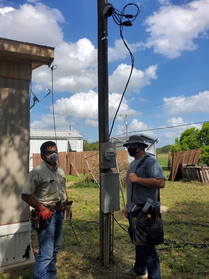 Electro Cooling Service technicians servicing the power and AC connections at a Rio Grande Valley home