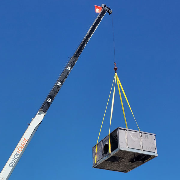 Electro Cooling Service crane hoisting a commercial rooftop HVAC package unit into place with rigging straps in McAllen, Texas